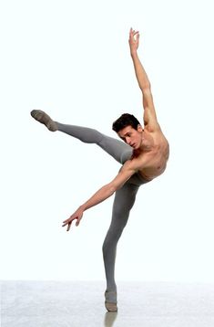 a shirtless man doing a trick on a skateboard in front of a white background