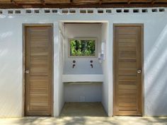 two wooden doors open in front of a white building