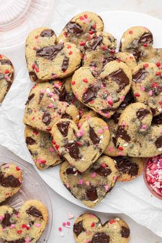 chocolate chip cookies with pink and red sprinkles arranged on a white plate