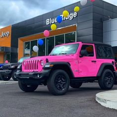 a pink jeep is parked in front of a blue ridge dealership on a cloudy day