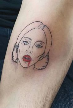 a woman's face has been drawn on her leg and is wearing a red lipstick