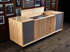 a record player sitting on top of a wooden cabinet in front of pictures and frames