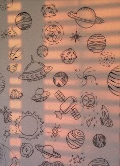 the sun is shining in front of a wall with doodled planets and stars on it