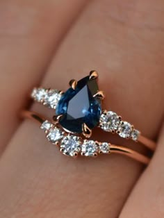 a woman's hand with a blue and white diamond ring on it