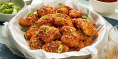 a bowl filled with fried food next to some dipping sauce