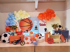 an indoor sports themed birthday party with balloons and decorations on the wall, including basketballs