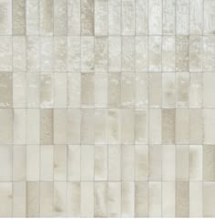 a white and beige tile wall with squares