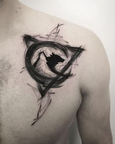 a man's chest with a black and white tattoo design on the left side