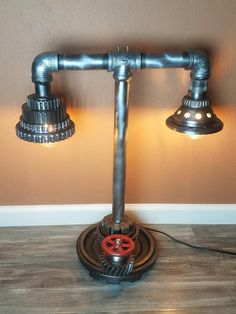 a lamp that is sitting on top of a wooden floor in front of a wall