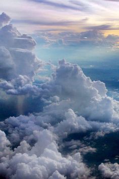 an airplane is flying high in the sky with clouds and sunbeams above it