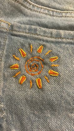 an embroidered sun on the back of a pair of jeans