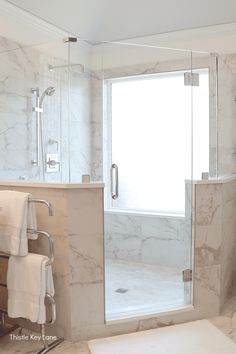 a bathroom with a walk in shower next to a white sink and bathtub under a window