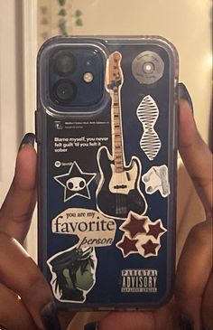 someone holding up their phone case with stickers on it