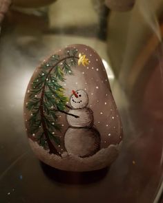 a painted rock with a snowman on it