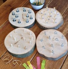 four wooden pegs sitting on top of a table next to some scissors and pins