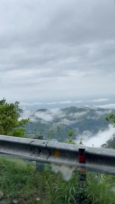 a view from the top of a hill with fog in the valley below