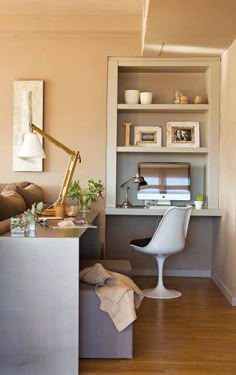 a living room with a desk, chair and bookshelf