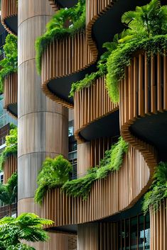 the building has many green plants growing on it's walls and balconies