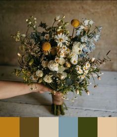 a person holding a bouquet of flowers in front of a color swatch with different colors