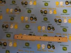 a ruler is laying on top of a blue wallpaper with tractors and farm animals