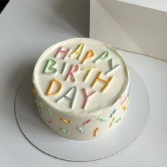 a birthday cake with white frosting and colorful sprinkles that says happy birthday