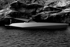 a white boat floating on top of a body of water next to a rocky shore