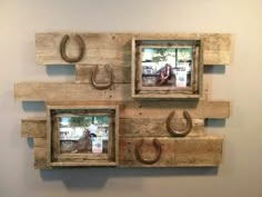 three wooden frames with horseshoes hanging on the wall