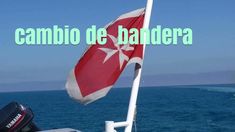 a flag on the back of a boat in the ocean with text reading cambio de bandera