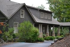 a large house sitting next to a lush green forest