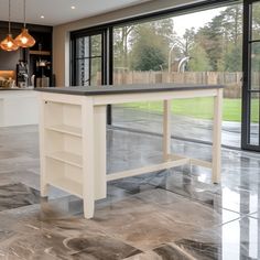 a kitchen with marble flooring and an island in front of glass doors that look out onto the back yard