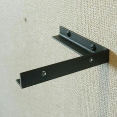 the corner of a wall with two metal brackets attached to it's back side