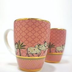 two pink cups with horses on them sitting next to each other