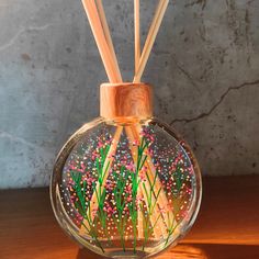 a glass vase with reeds in it on a table