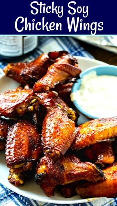 chicken wings on a white plate with ranch dressing in the background and text overlay that reads sticky soy chicken wings