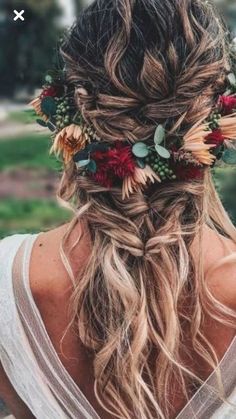 a woman with long hair and flowers in her hair is looking down at the ground