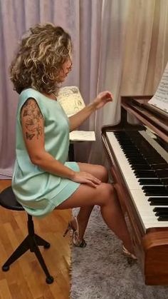 a woman sitting in front of a piano