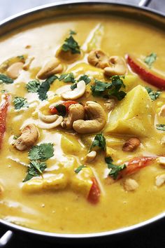 a pan filled with food and garnished with cashews on the side