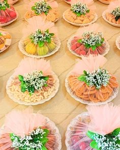 there are many desserts on the table with pink tulle skirts and baby's breath flowers