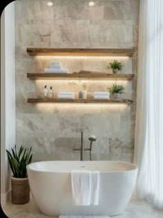 a white bath tub sitting in a bathroom next to two shelves with towels on them