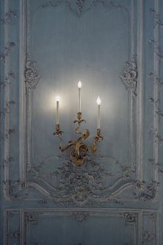 an ornately decorated wall light with two candles