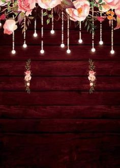 pink flowers hanging from the ceiling with lights above them on a dark wooden background photo