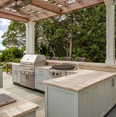 an outdoor kitchen with grill and seating area