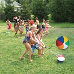 several children playing with a beach ball in the grass