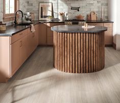 a kitchen with wooden cabinets and marble counter tops, along with an island in the middle