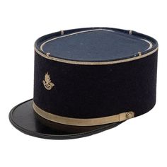 A rare French Military Academy Officer's hat or cap from the 1970s. These special and unique hats are part of the uniform of students studying to become officers in the French Military. This cap features a black leather brim on black felt with a blue top. There is a gold band around the brim and gold band at the top with a gold braid on the top and a gold emblem on the front. 6.25"w x 10"d x 4.25"h. Wear consistent with age and use. French Military, Black Tears, Military Officer, Military Academy, Military Hat, Unique Hats, Vintage Military, Arte Popular, Black Felt