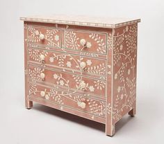 a pink and white painted dresser with flowers on it