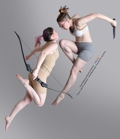 two women are jumping in the air with their bow and arrow attached to their backs