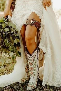 a woman in cowboy boots holding a bridal bouquet