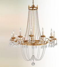 a gold chandelier with crystal beads hanging from the ceiling