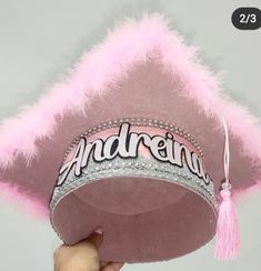 someone is holding up a pink hat with the word andernia on it